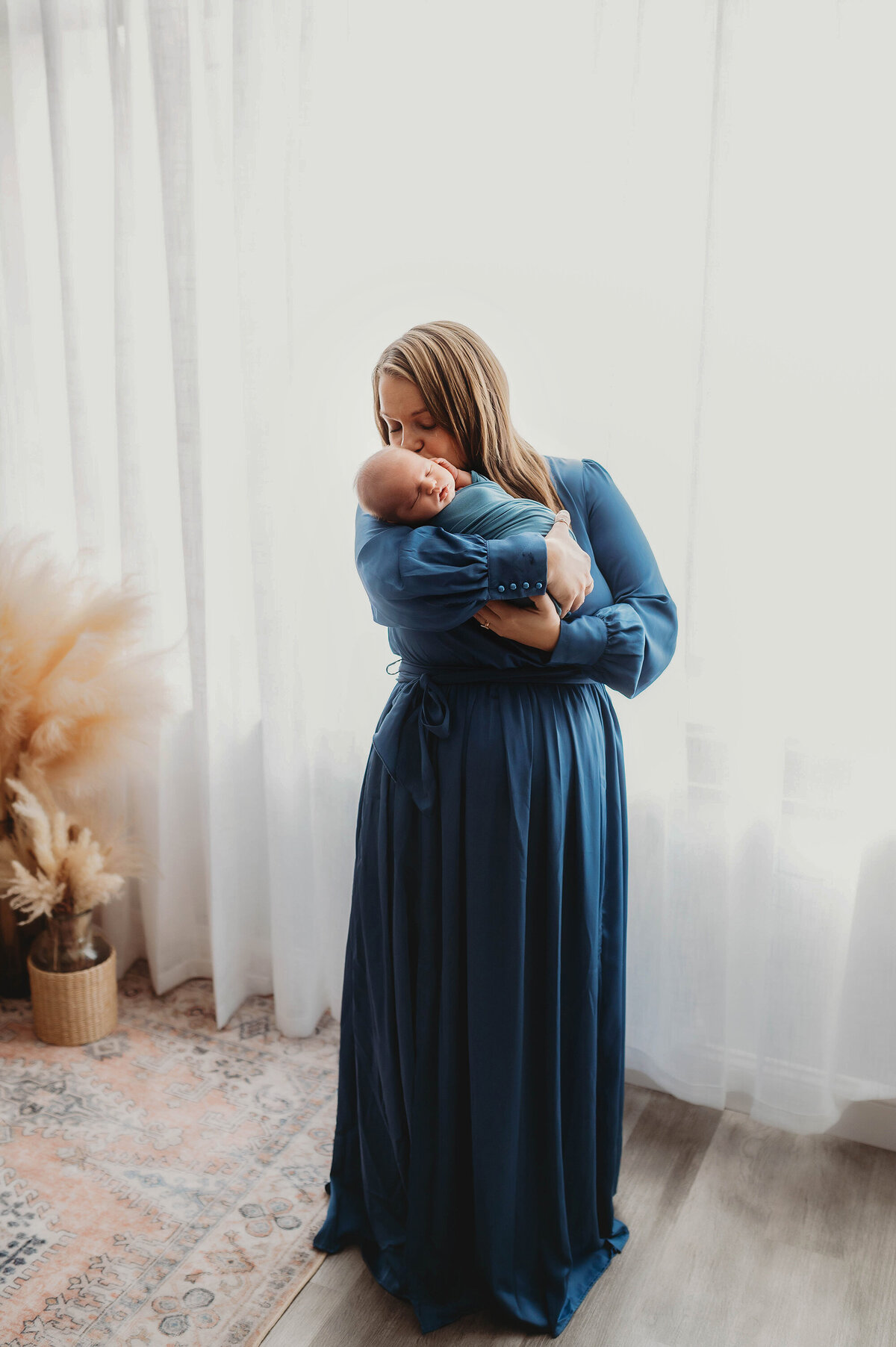 Mother embraces her infant during Newborn Photoshoot in Charleston.
