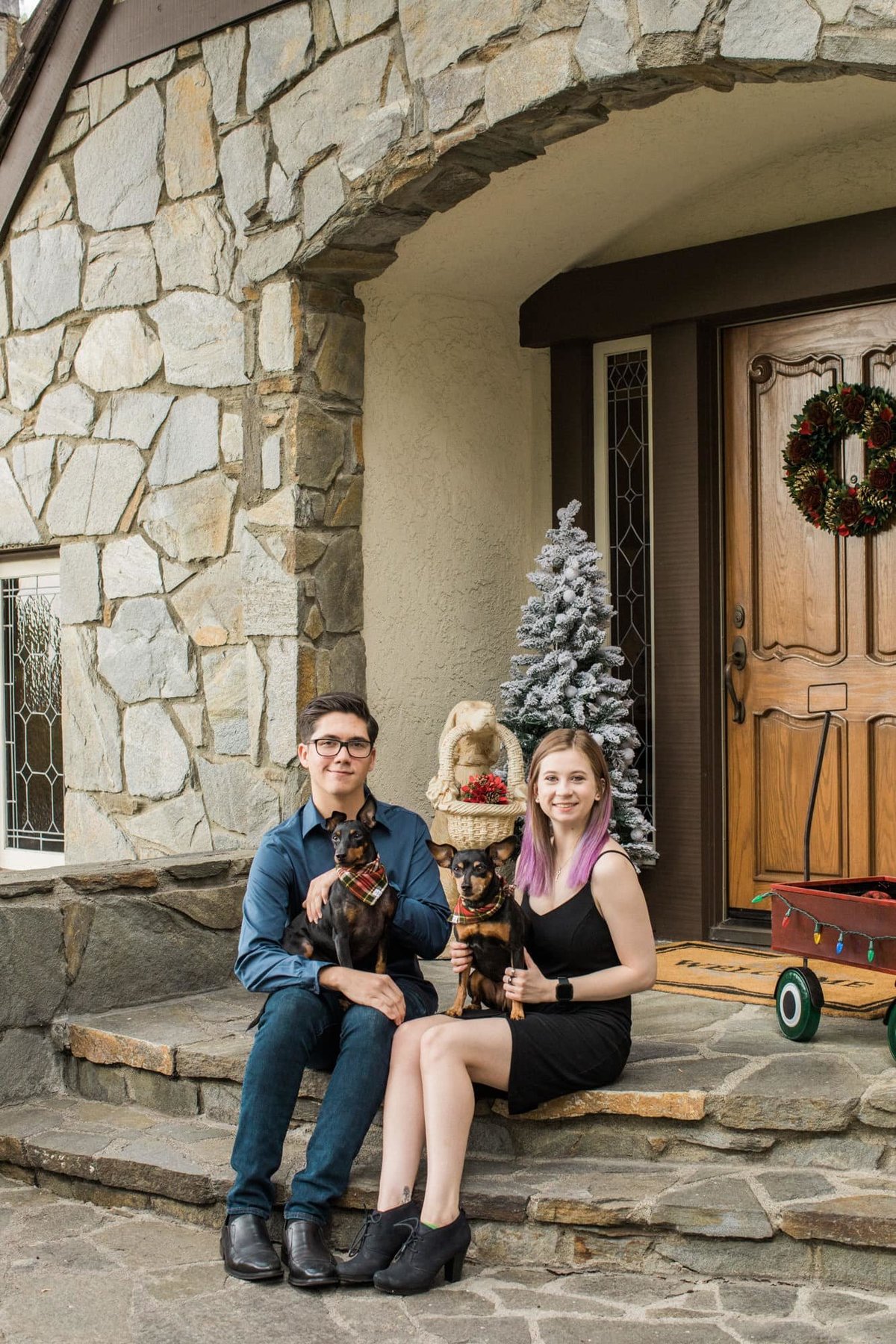 Young teenagers pose outside their home with their dogs