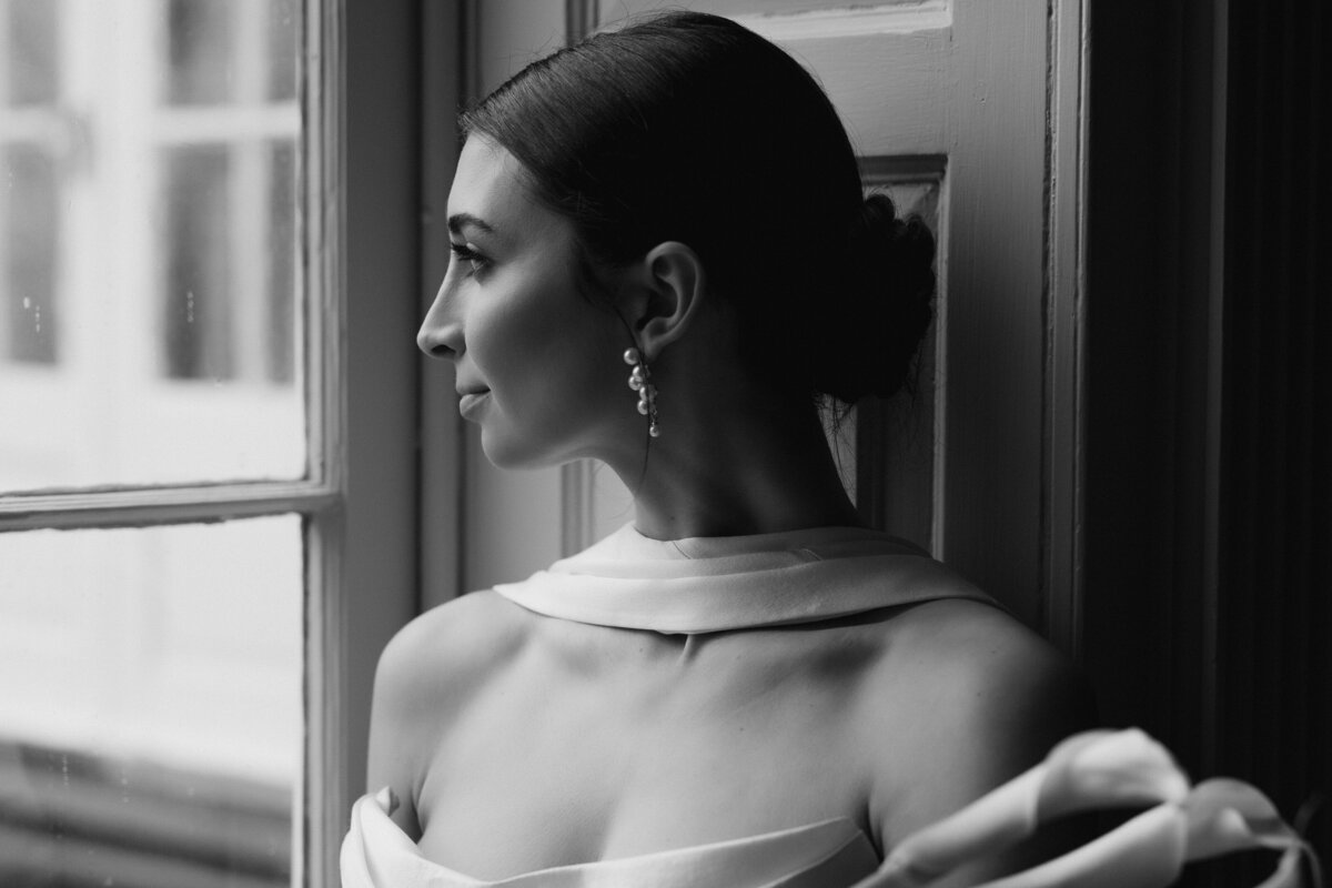 Bride touching her neck on the balcony. at the. Westmoreland Club