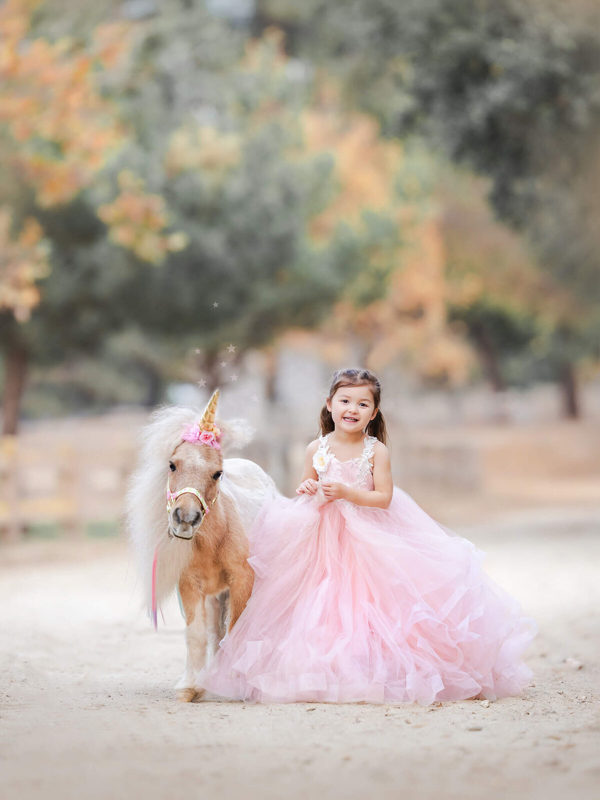 little girl with a unicorn in los angeles photoshoot wearing pink princess dress