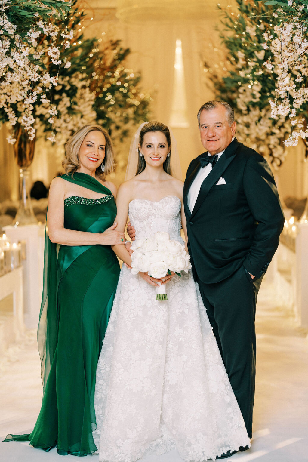 The bride standing with her mother and father on her wedding day. 