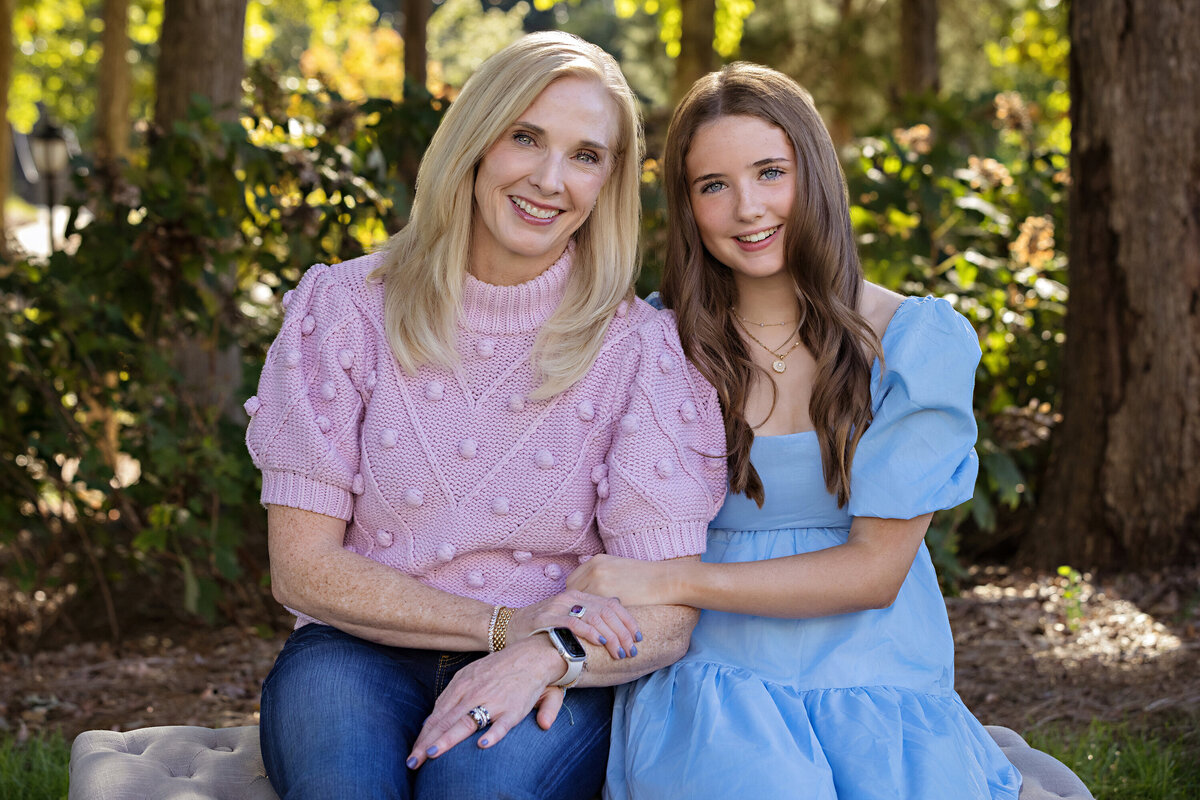Mother and daughter sharing a sweet moment on a bench surrounded by trees in Charlotte NC.