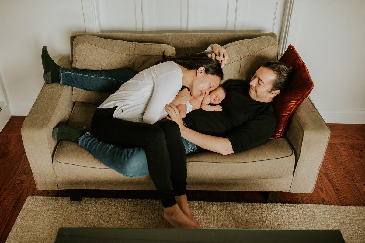 Lifestyle Bay Area newborn photography of baby and family intimately snuggled on couch