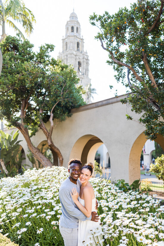 engaged-couple-in-white-daisies-Alcazar-Garden-balboa-park-san-diego
