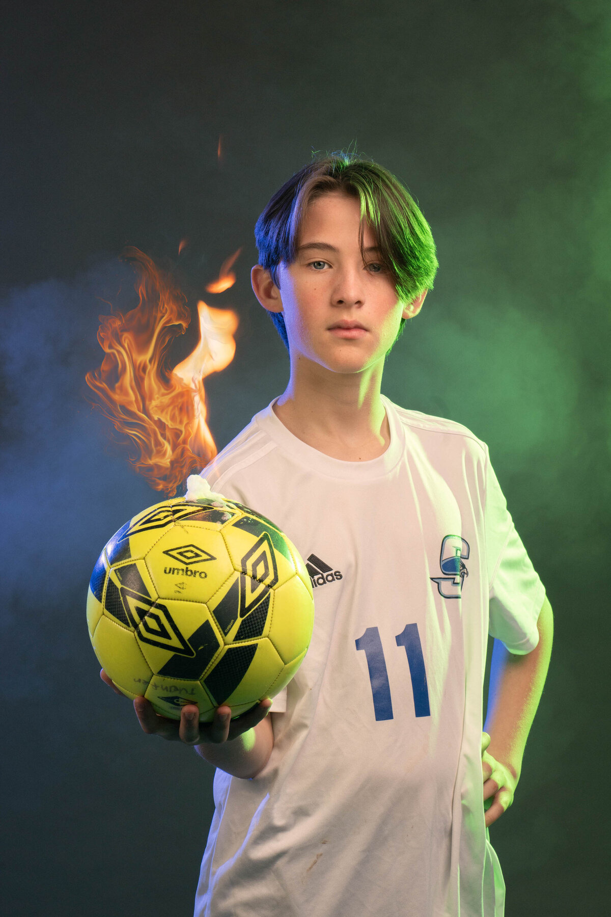 A person holding a soccer ball that is on fire 