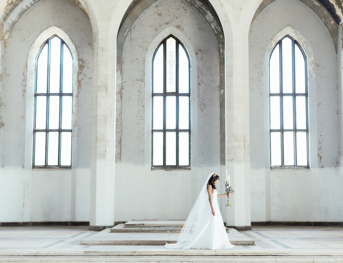 bride with candelabra in abandoned cathedral ruins, wedding venue in Croatia