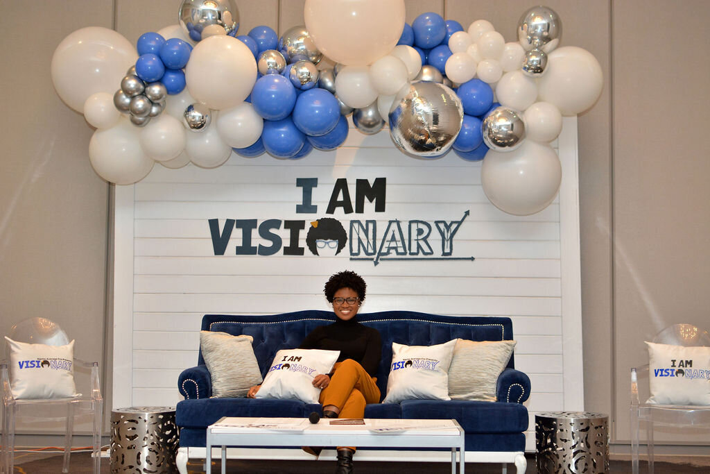 Blue, white and silver corporate backdrop design with navy couch photo booth