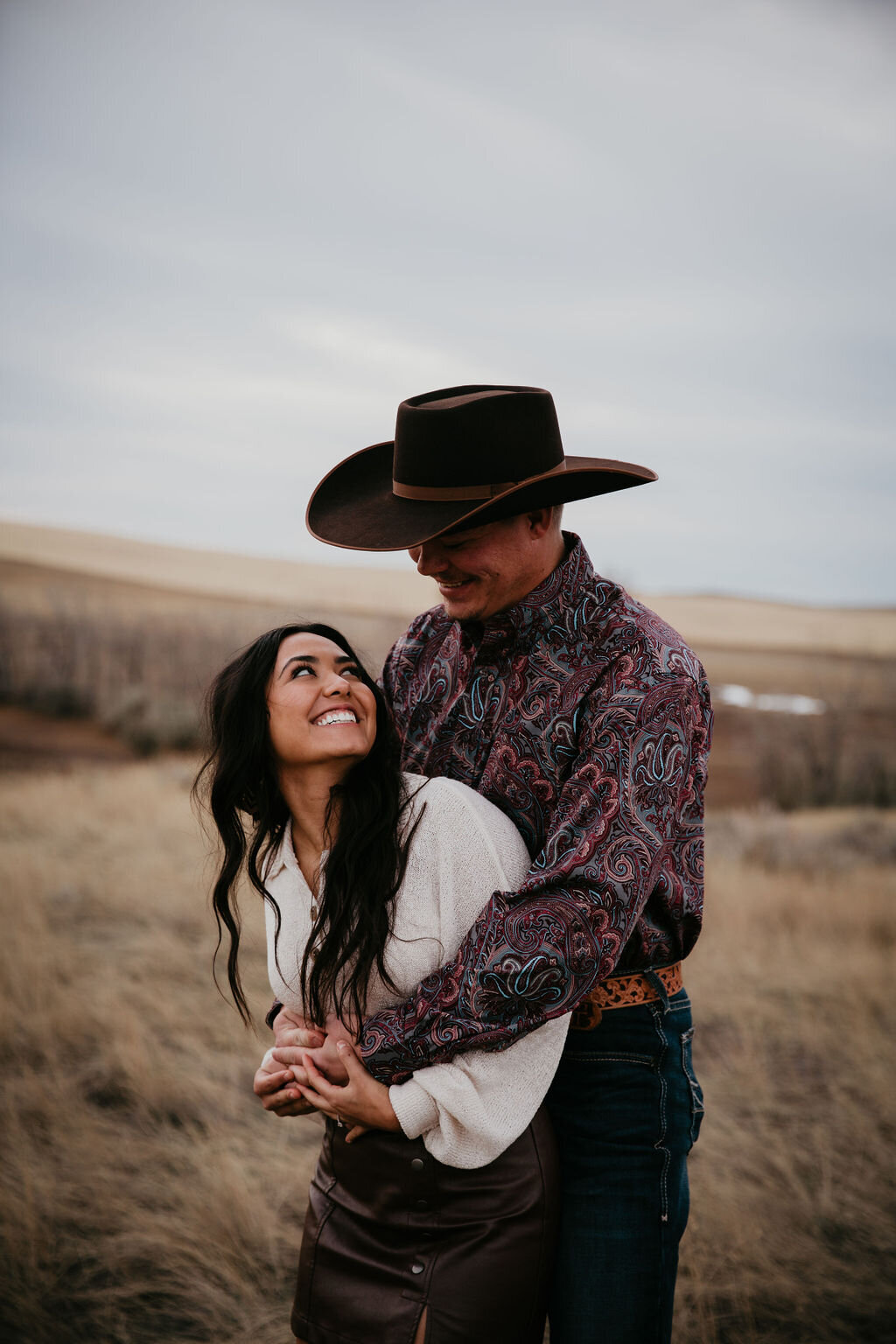 A couple smiling in an engagement photoshoot