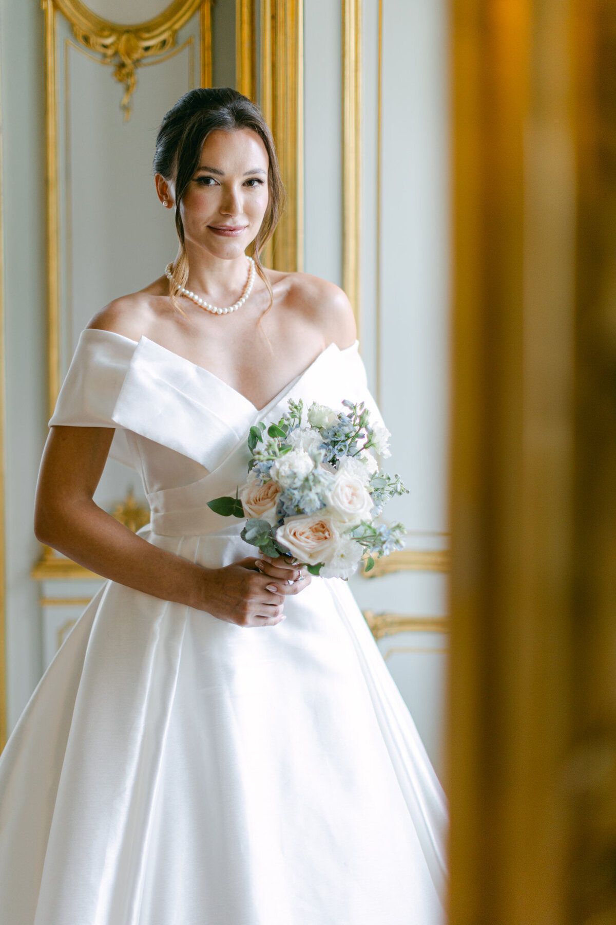 ECLAT Destination bride holding her wedding bouquet at white salon in wedding villa Coburg