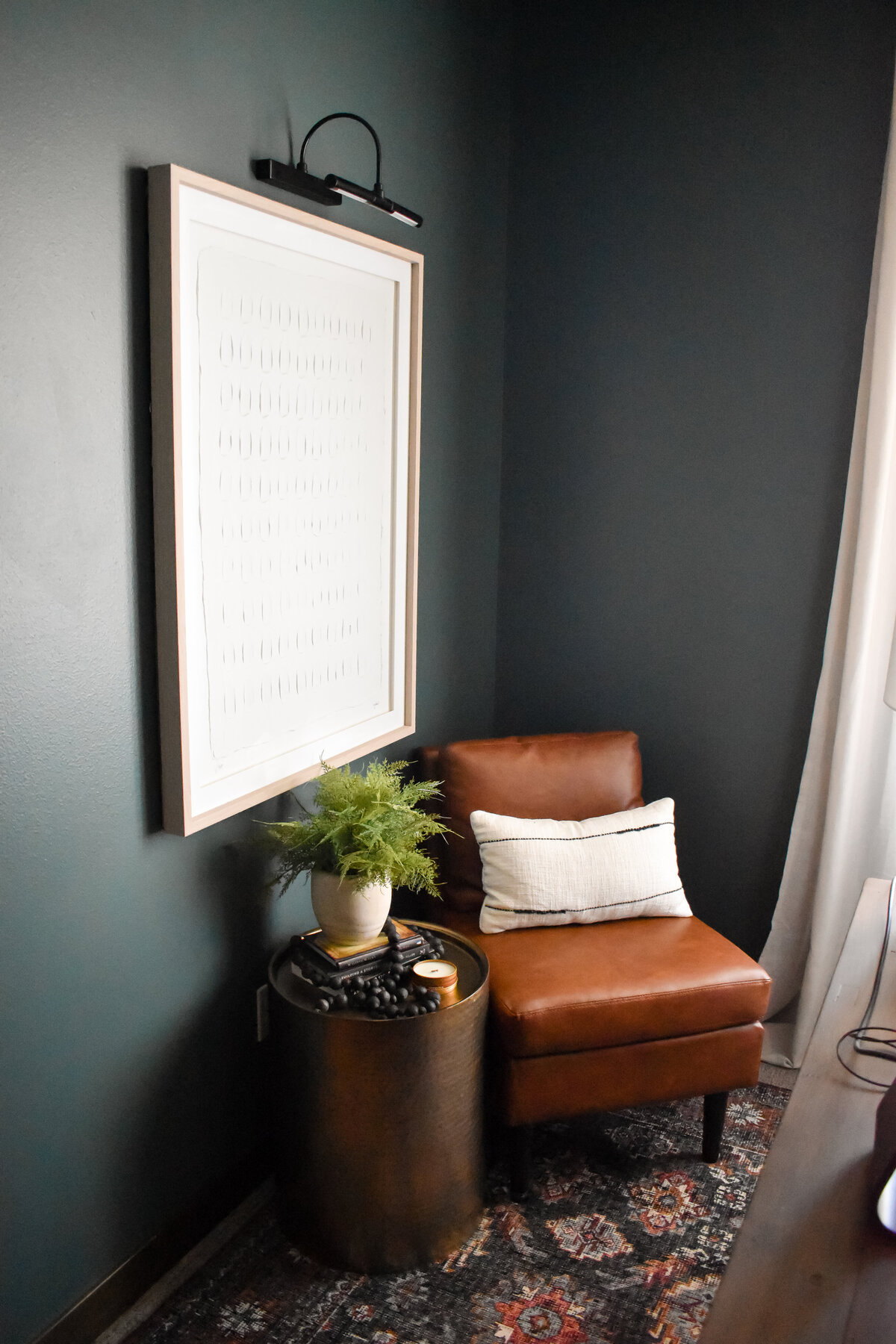 A leather chair sits in the corner of a dark and moody office