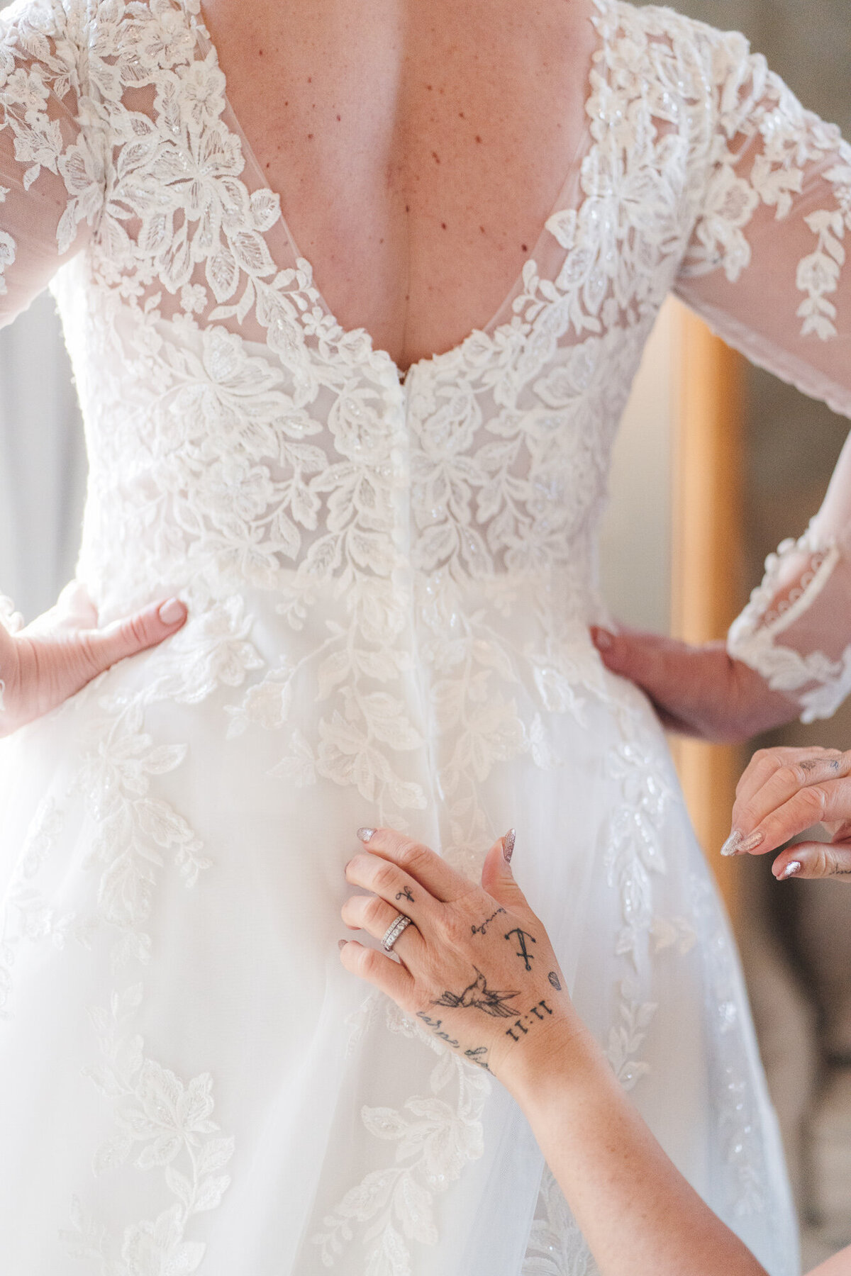 Brides white dress being fastened up taken by Anthony Horseman Photography and Film