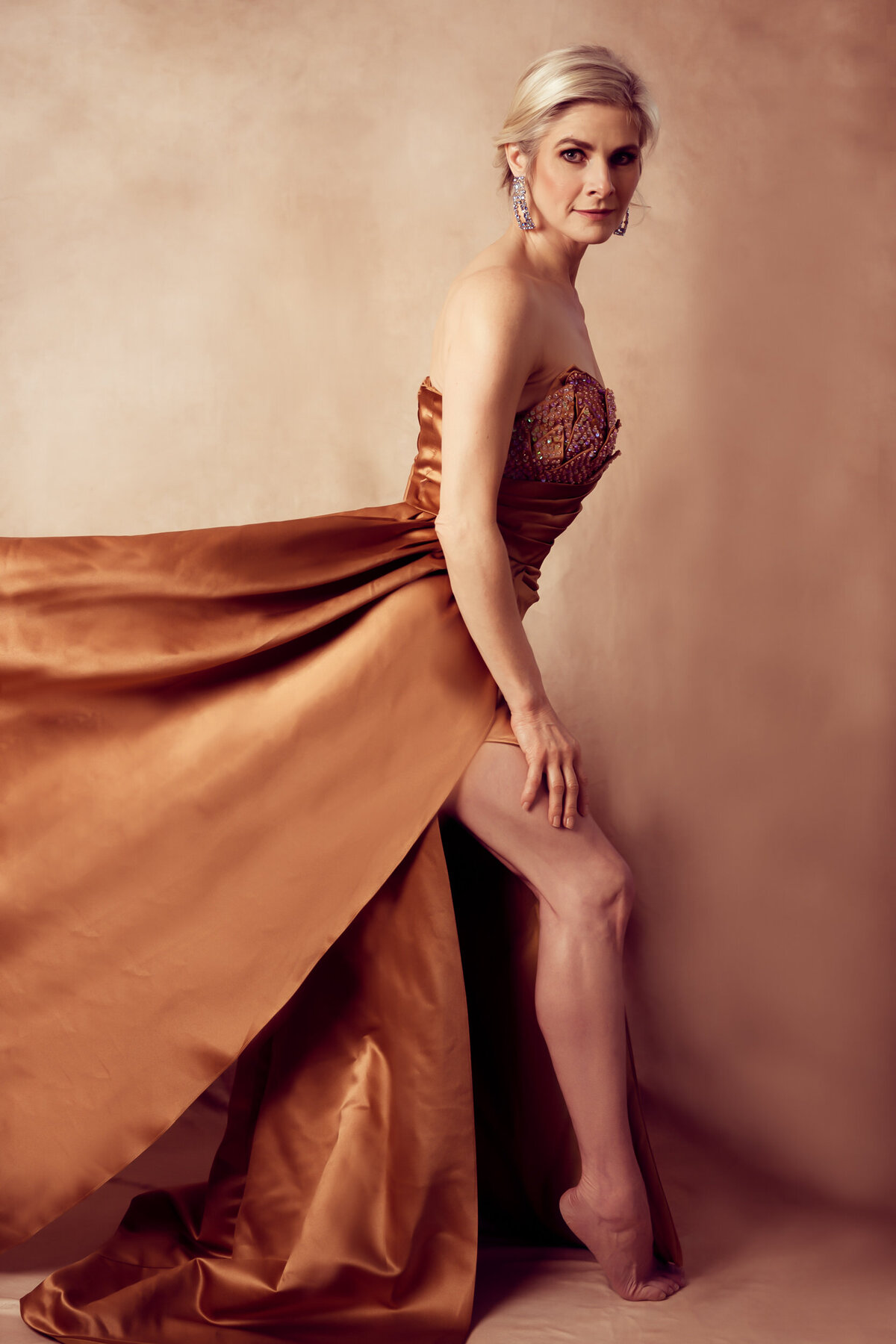 A blond woman posing to the camera side ways showing her legs
