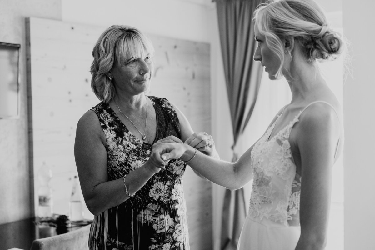 Bride’s mother adjusting wedding gown strap