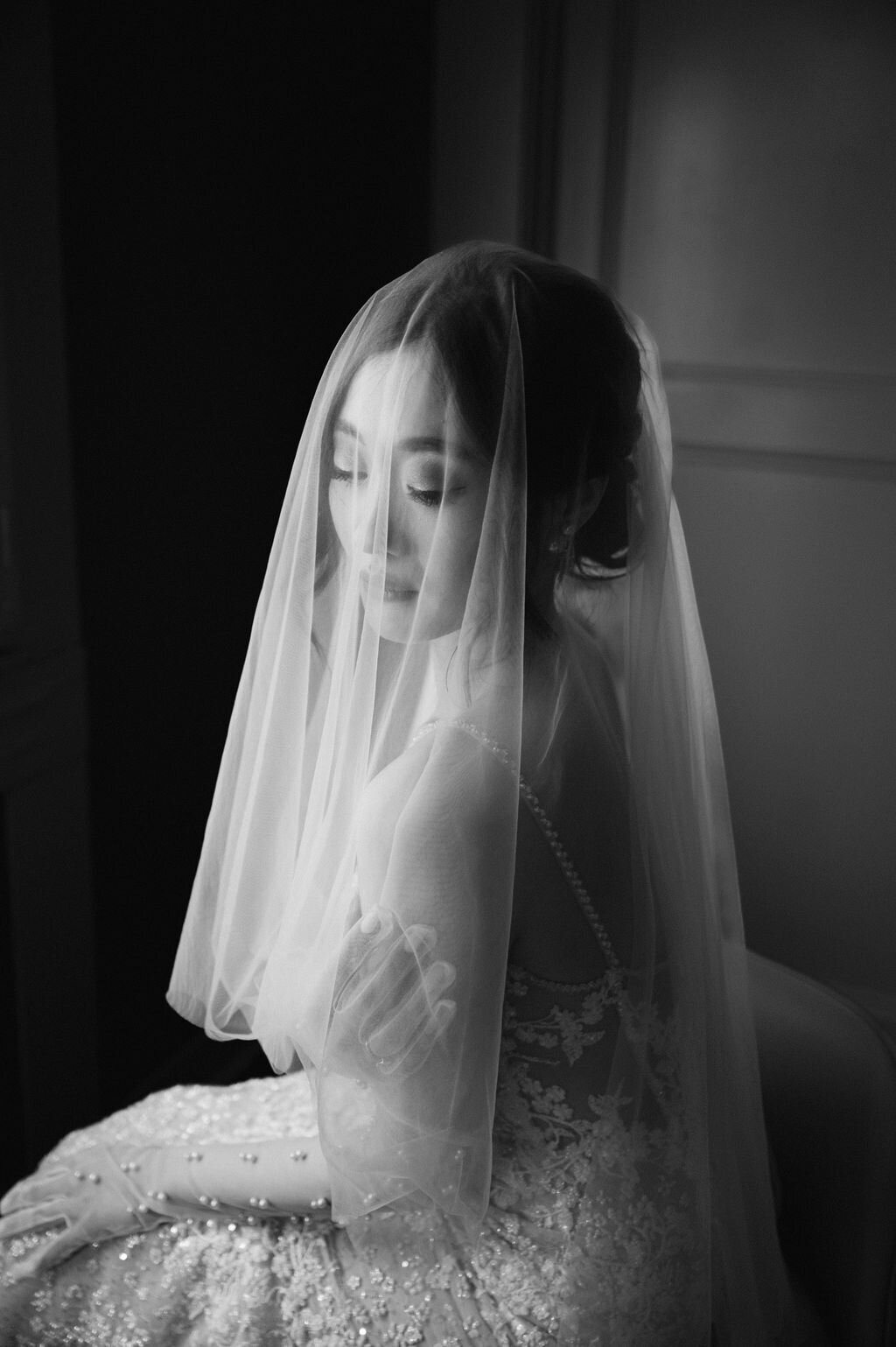 black and white photo of a bride with her veil over her head in dreamy contrast lighting taken by Jekyll Island Photographer, Rhonda Rowell