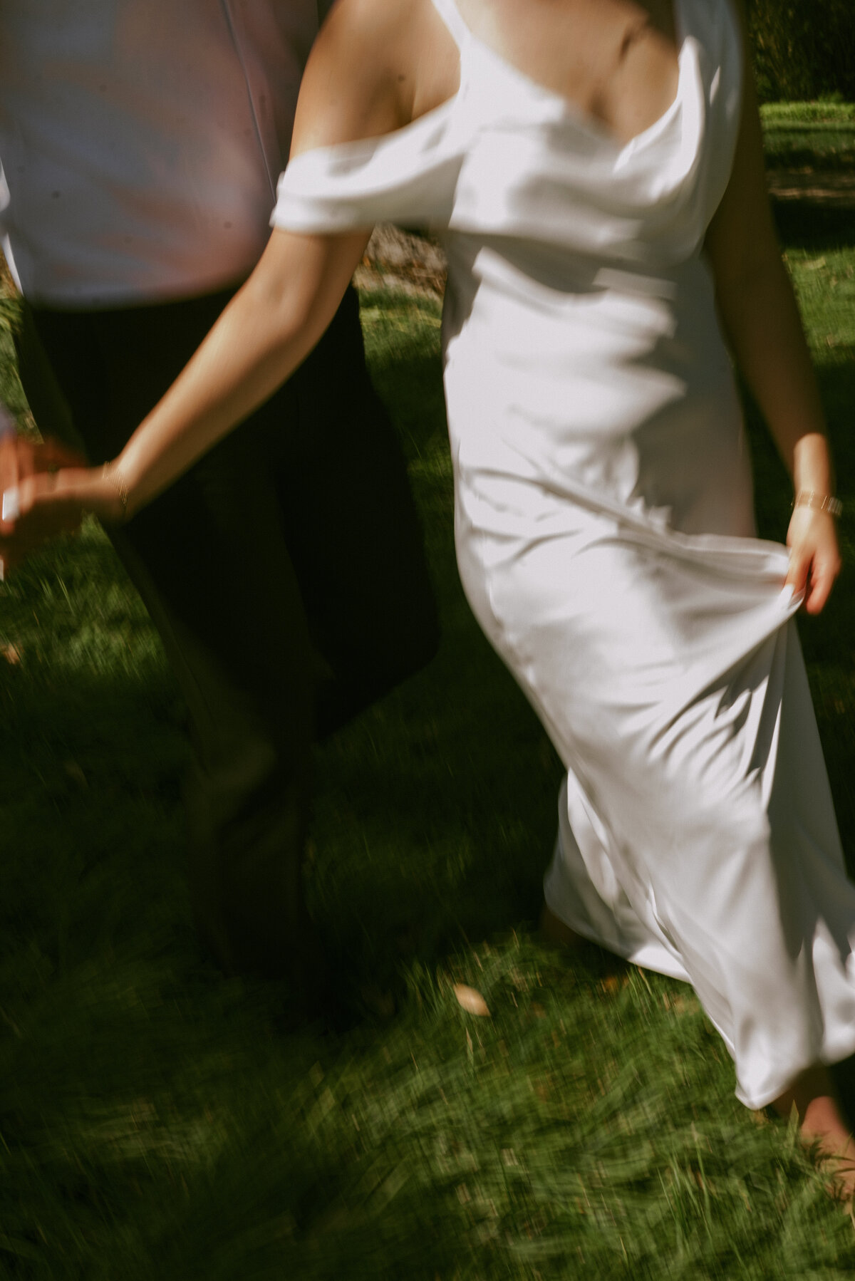 A cropped photos of a wedding couple walking, showing motion blur. 