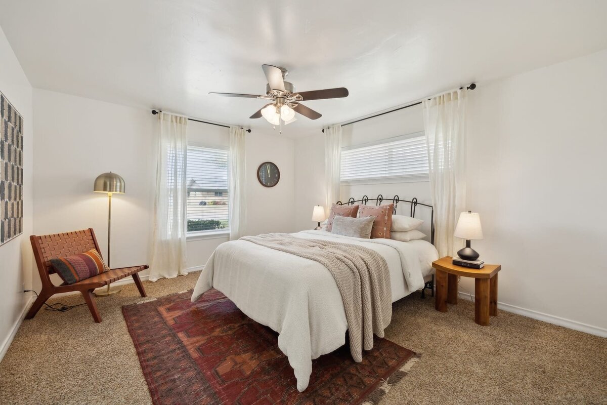 Primary bedroom at 3120 Chapel Downs Dr Dallas TX showcasing large windows, neutral palette, plush carpet, and cozy modern decor — listed by Haven Realty Group.
