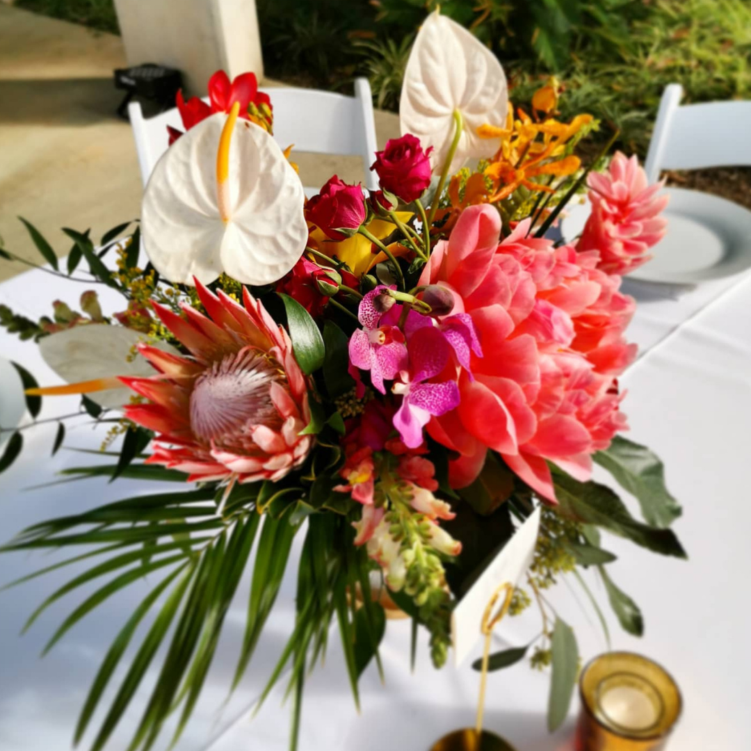 modern tropical centerpiece with anthirium peony and protea
