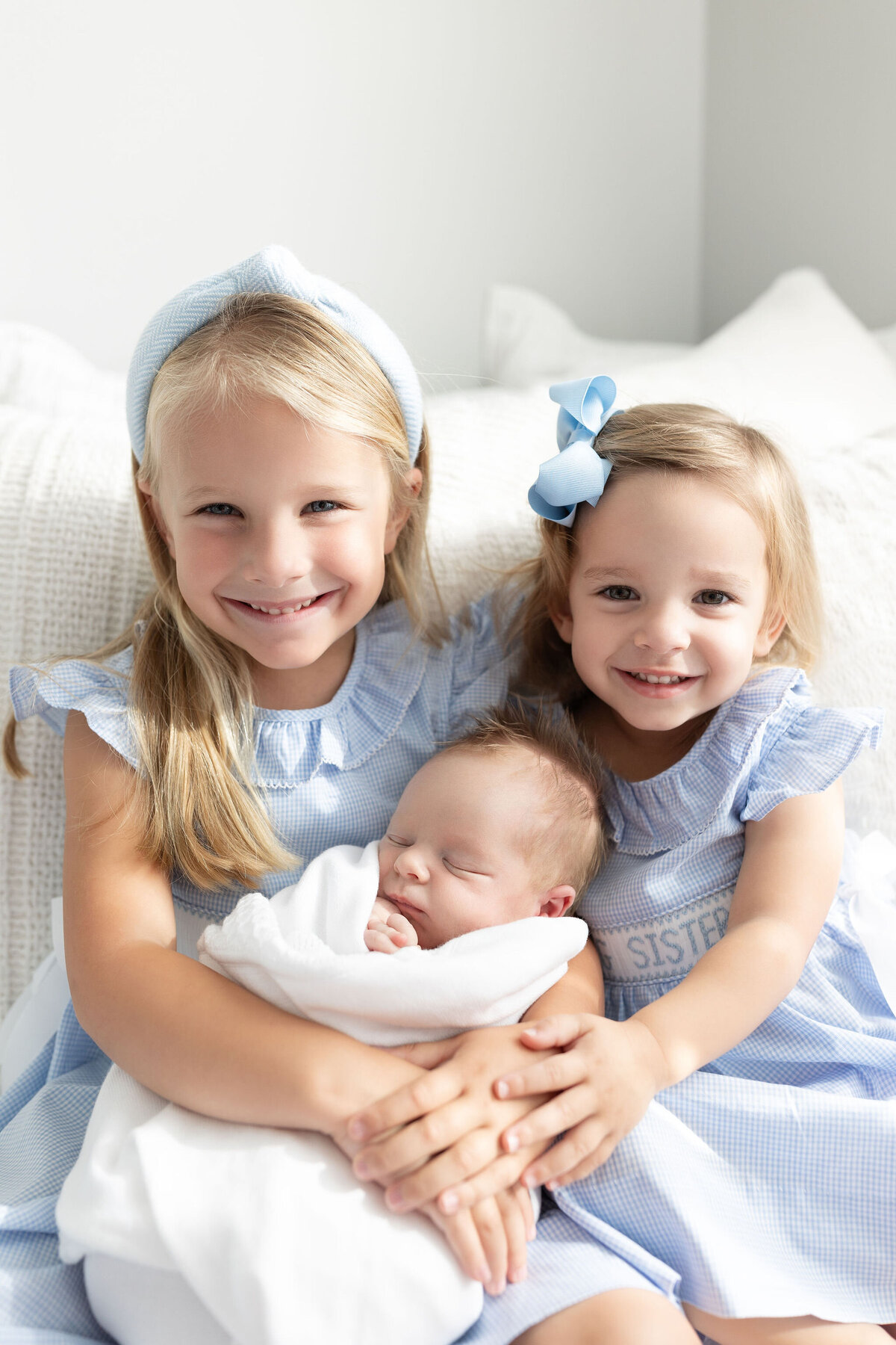 Siblings holding baby