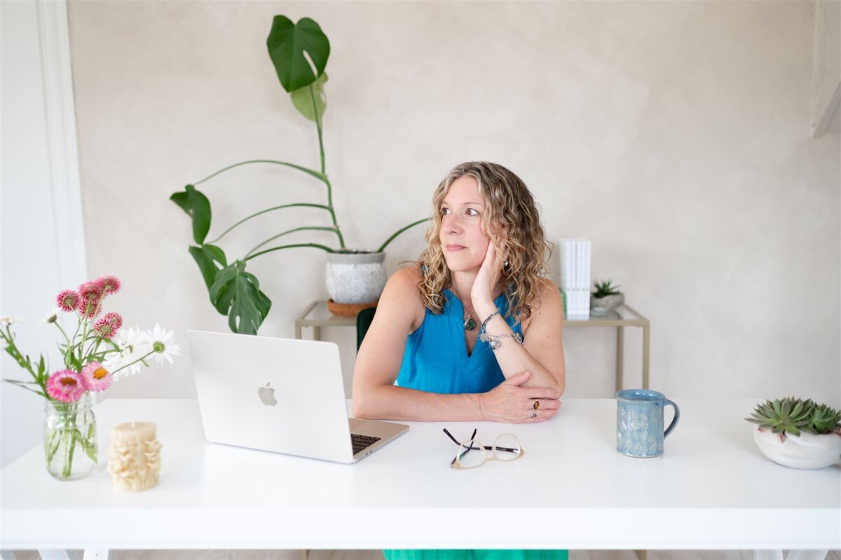 A woman, Heidi Schauster, a dietitian, sits at a desk working on her laptop.