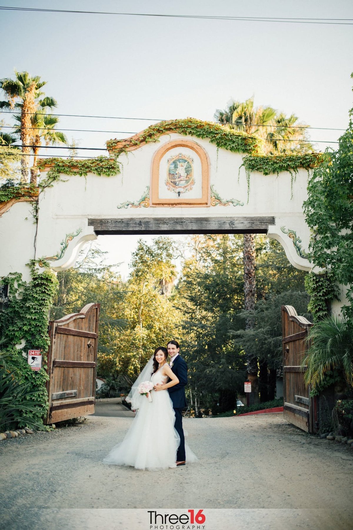 Bride and Groom pose at the Rancho Las Lomas entrance gate