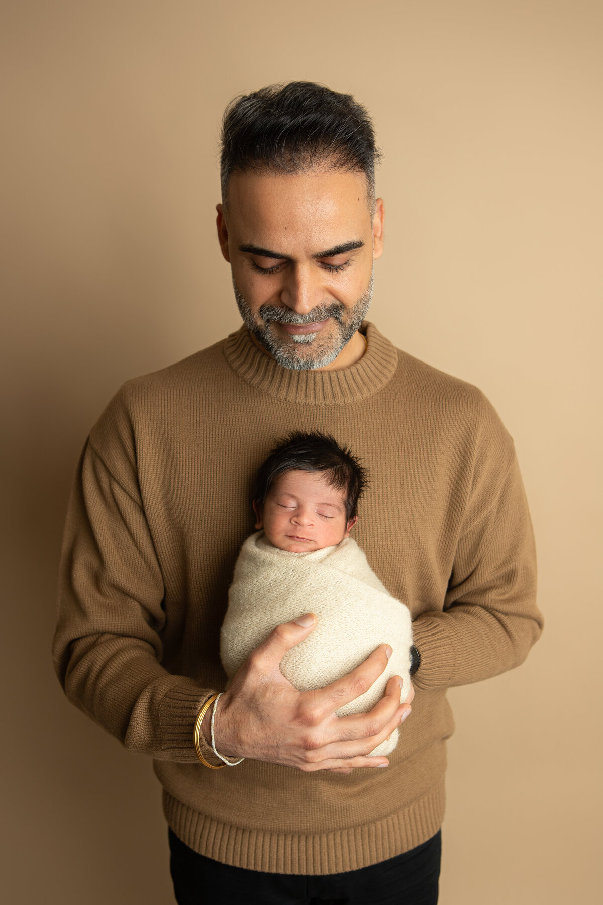 Newborn photography baby and dad pose with pecan backdrop