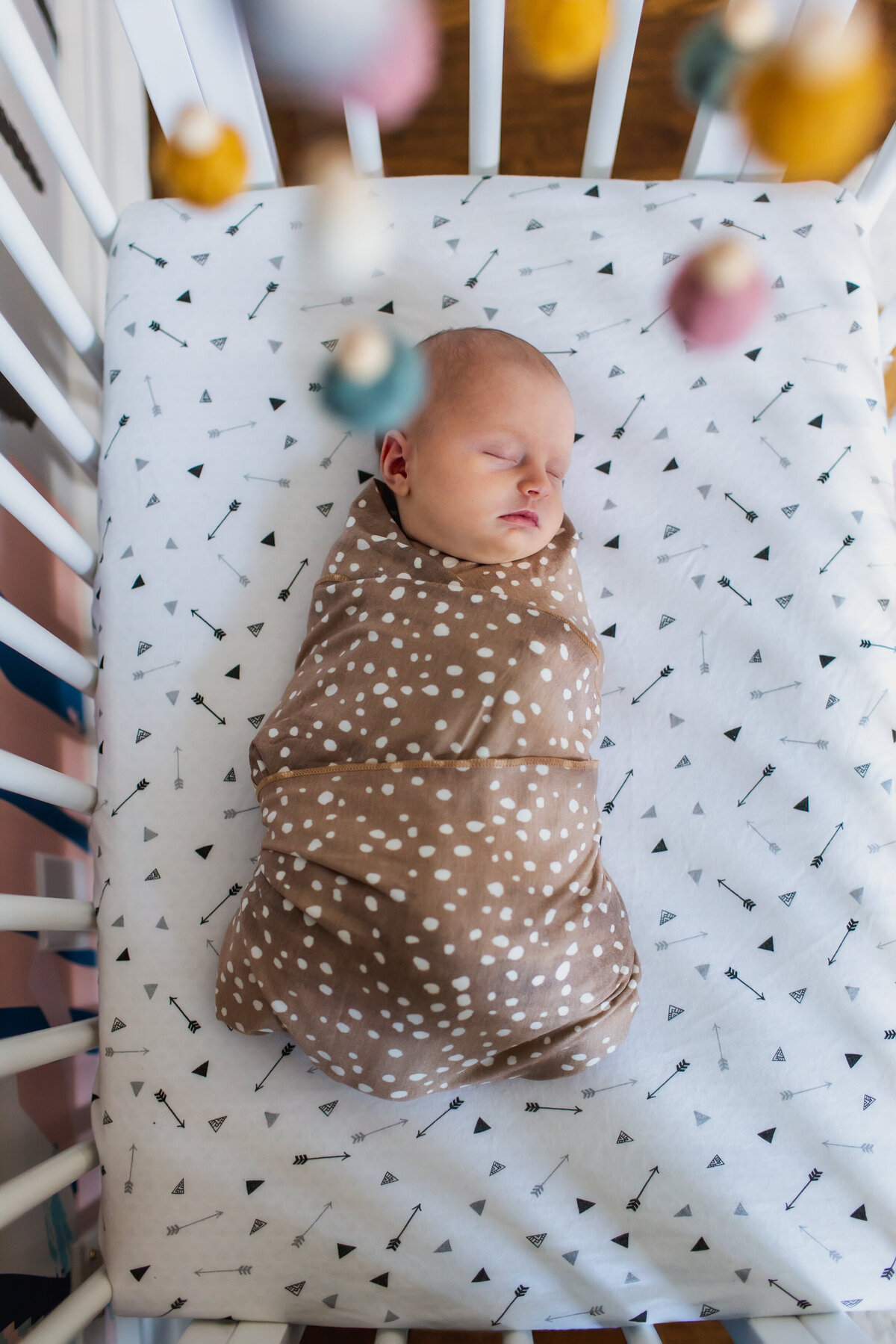 Overhead photo of baby girl sleeping peacefully in her crib.