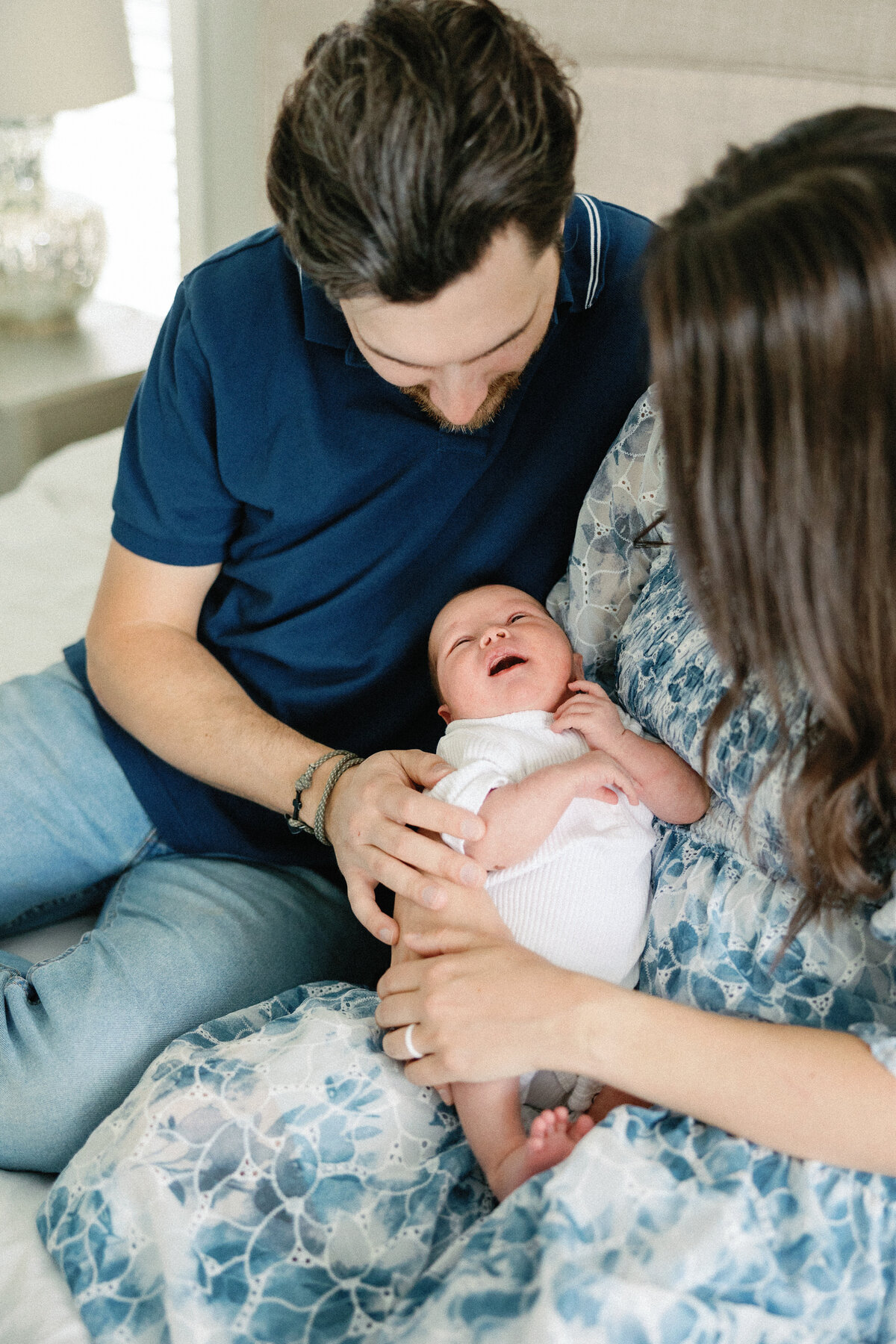 mom and dad admiring baby on master bed