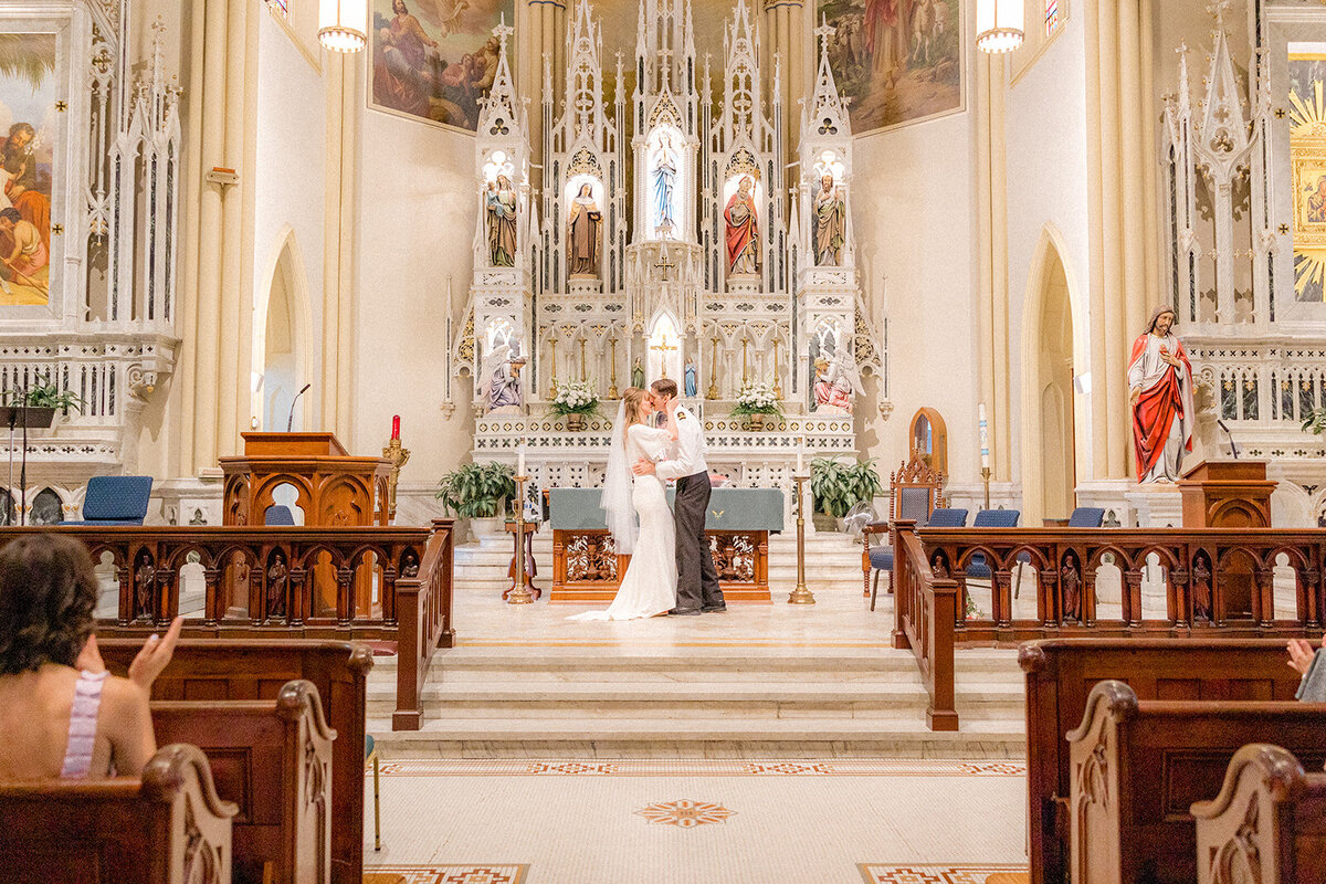 Bride and groom kissing in chapel