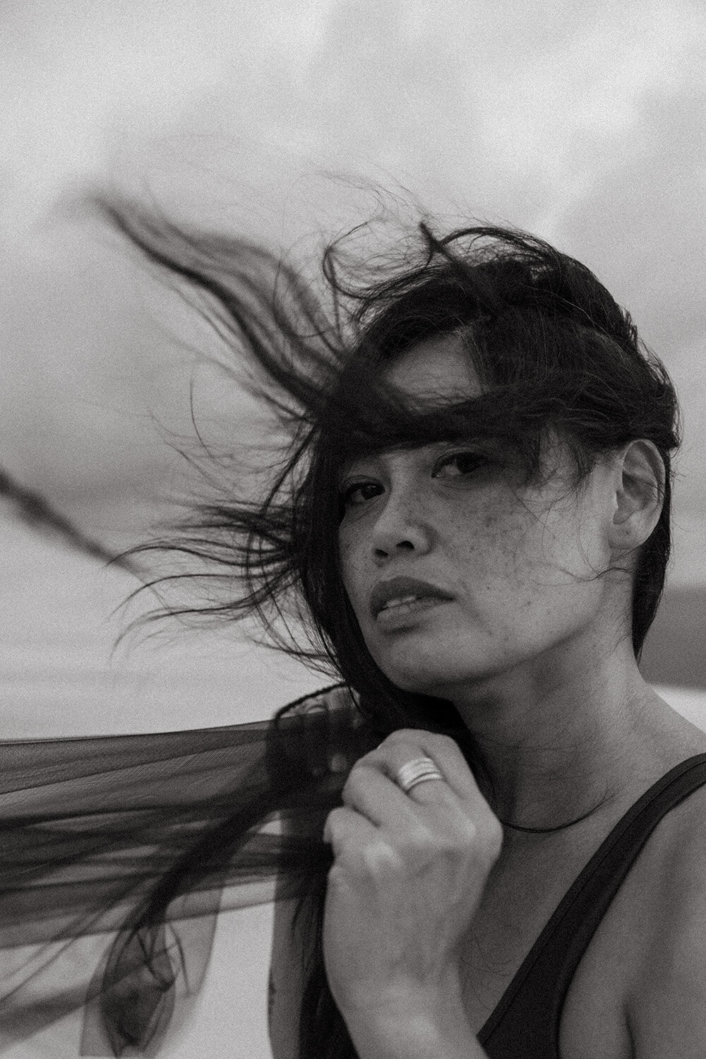 Emotive brand session in black and white for creative artist, windswept hair  at sunrise