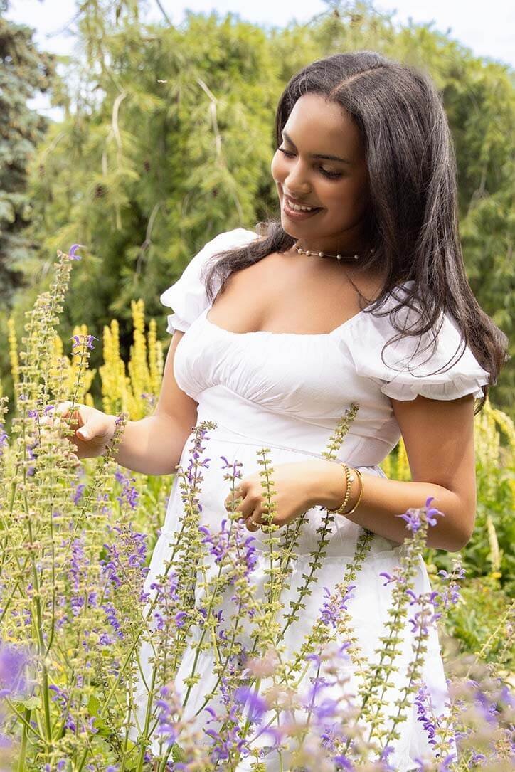 senior-girl-looking-at-flowers-in-garden