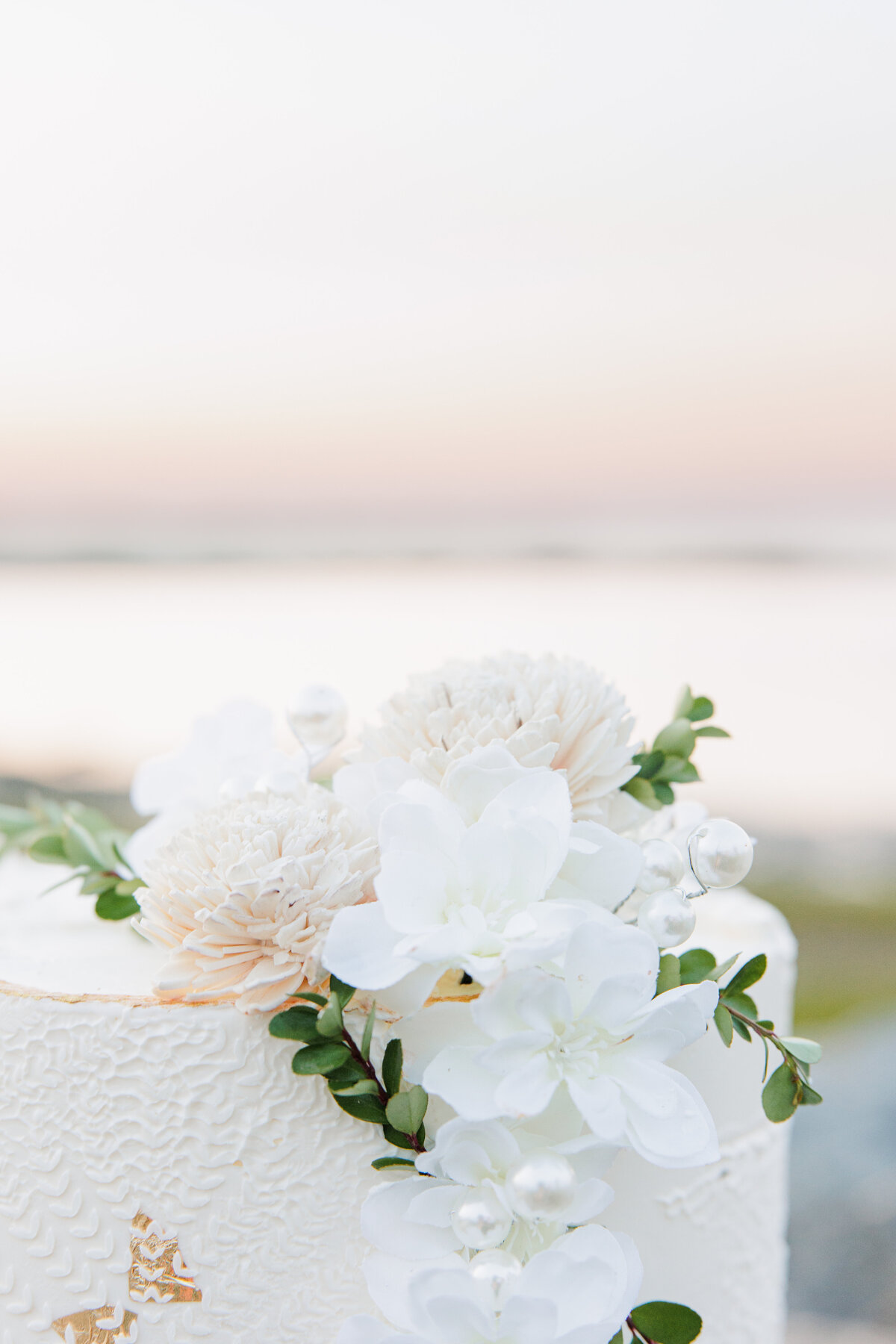 Close up of floral details on wedding cake at Gray's Beach