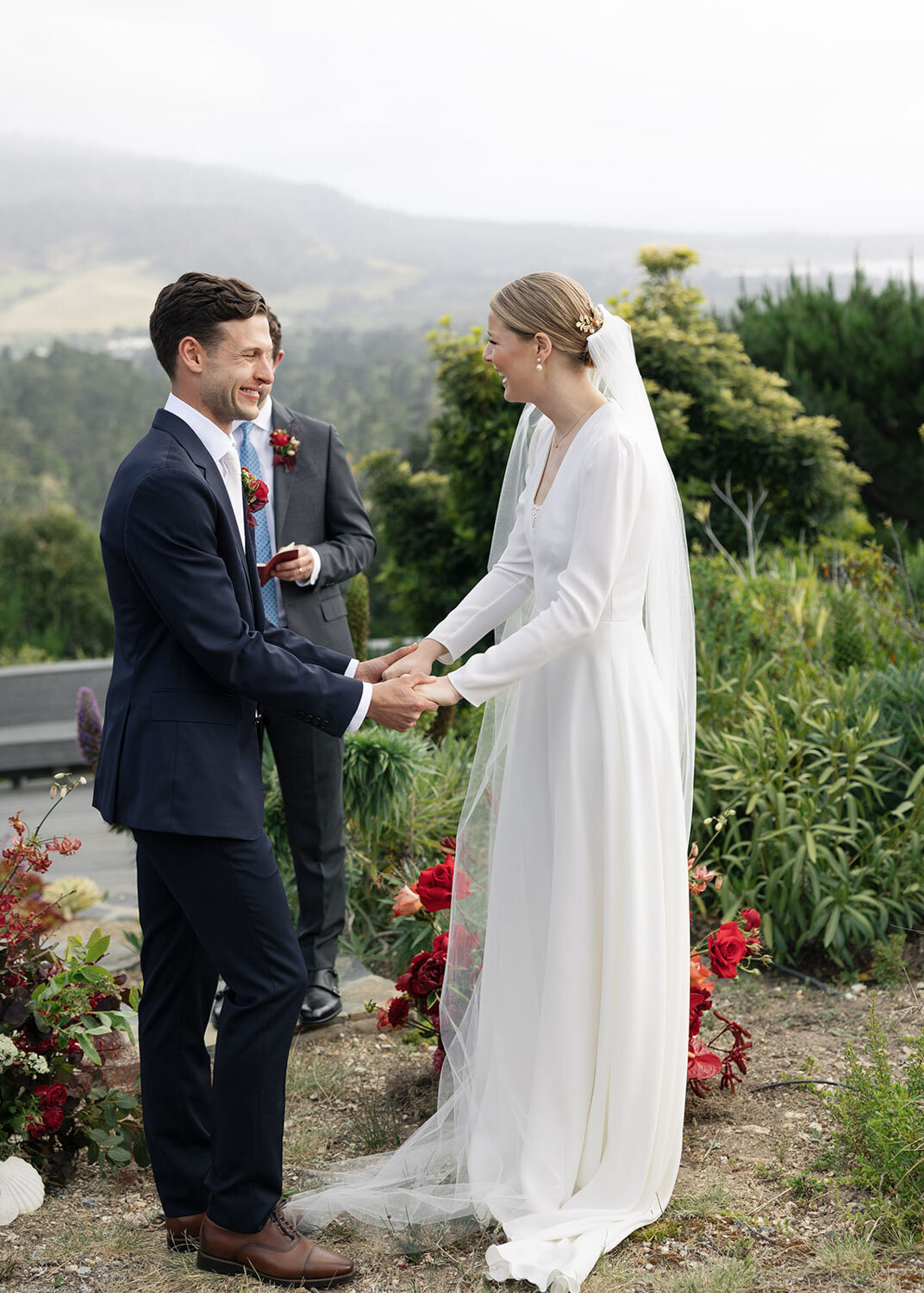 Bride and groom holding hands and smiling during their ceremony