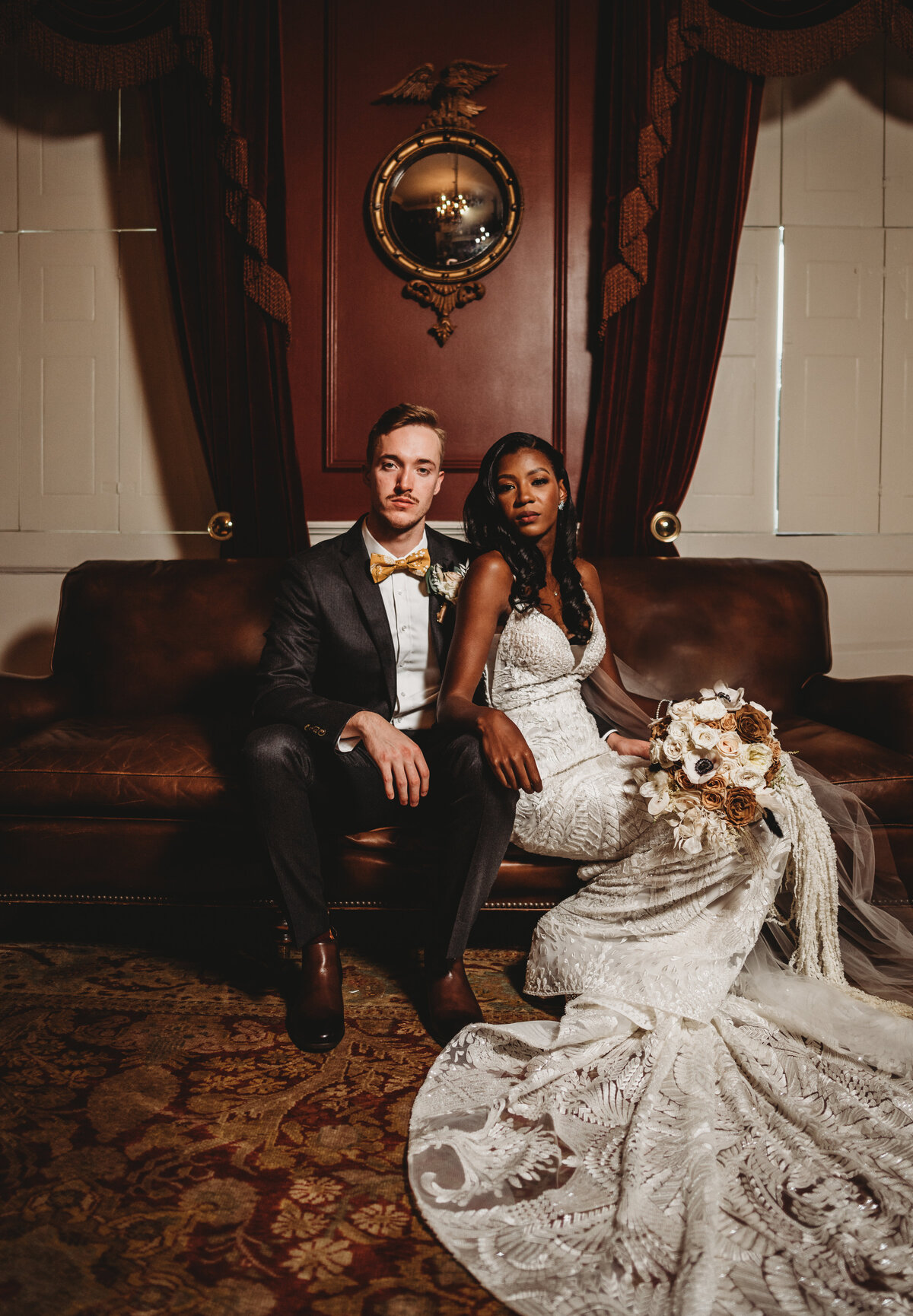 Bride and groom sitting in a lounge together on a leather couch for indoor wedding photography with Maryland wedding photographer