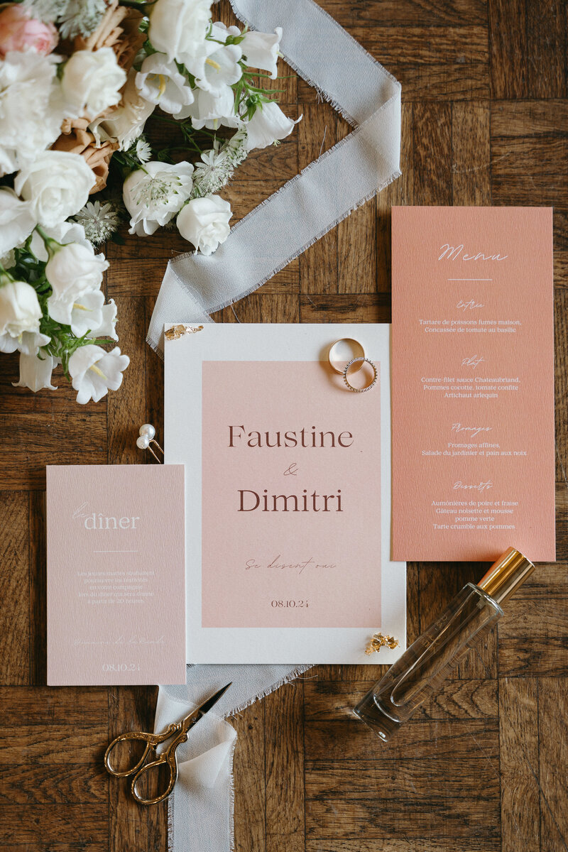 Ensemble de papeterie de mariage posé sur un parquet avec éléments de décor. Scène imaginée par Nos moments Ensebmle, organisation de mariages Vendée et Loire Atlantique