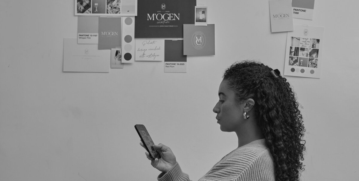 Side profile of woman looking at phone with moodboard in the background