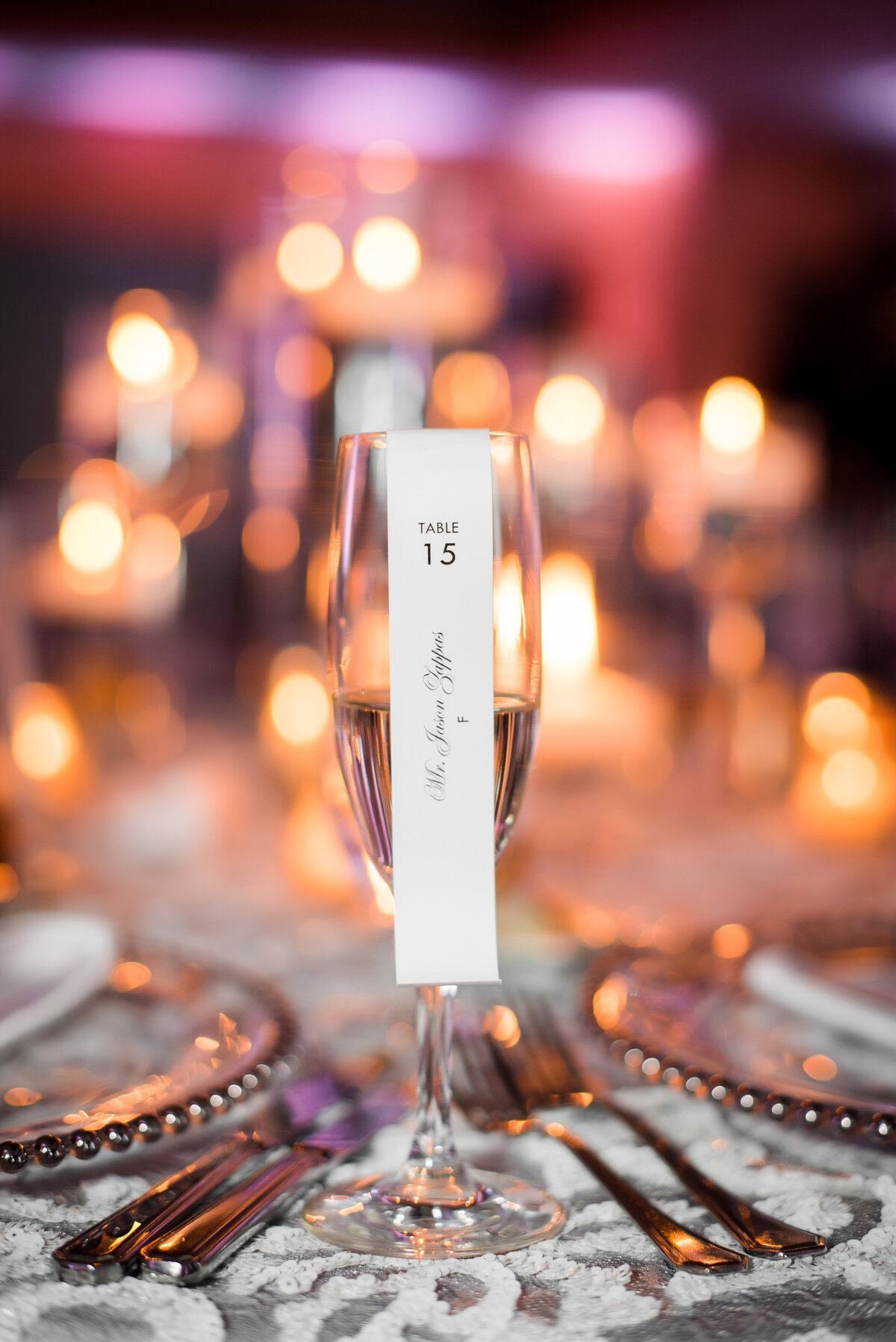 wedding champagne backlit with candles and a nametag with a scroll