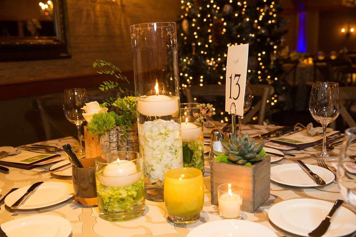 composite style centerpiece of floating candles, barked vase with succulents, vase with submerged hydrangea