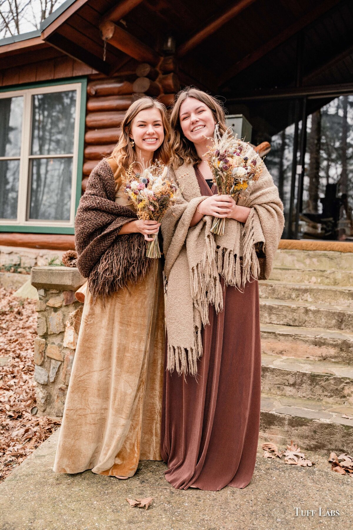 Bridesmaids hold their dried flower bouquets at an outdoor winter wedding.