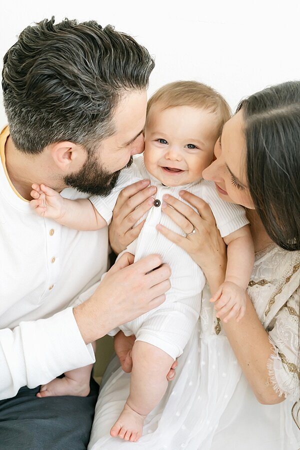 Mom and dad snuggling 1 year old by Louisville Portrait Photographer