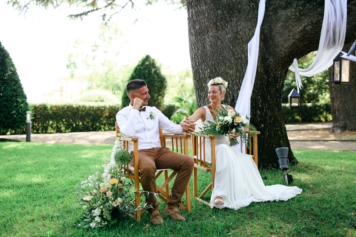 bride-and-groom-seated-holding-hands-at-luxury-wedding-in-antibes