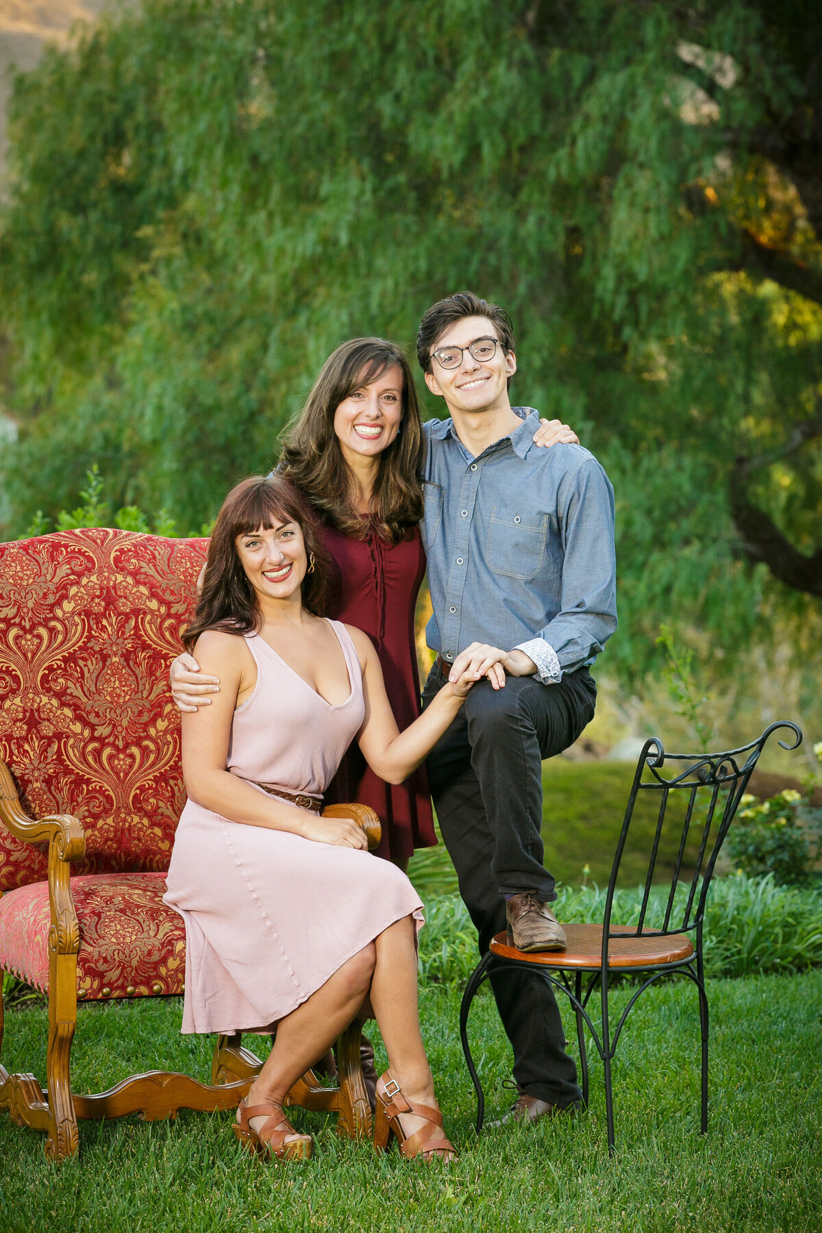 Three older siblings smiling with their arms around each other