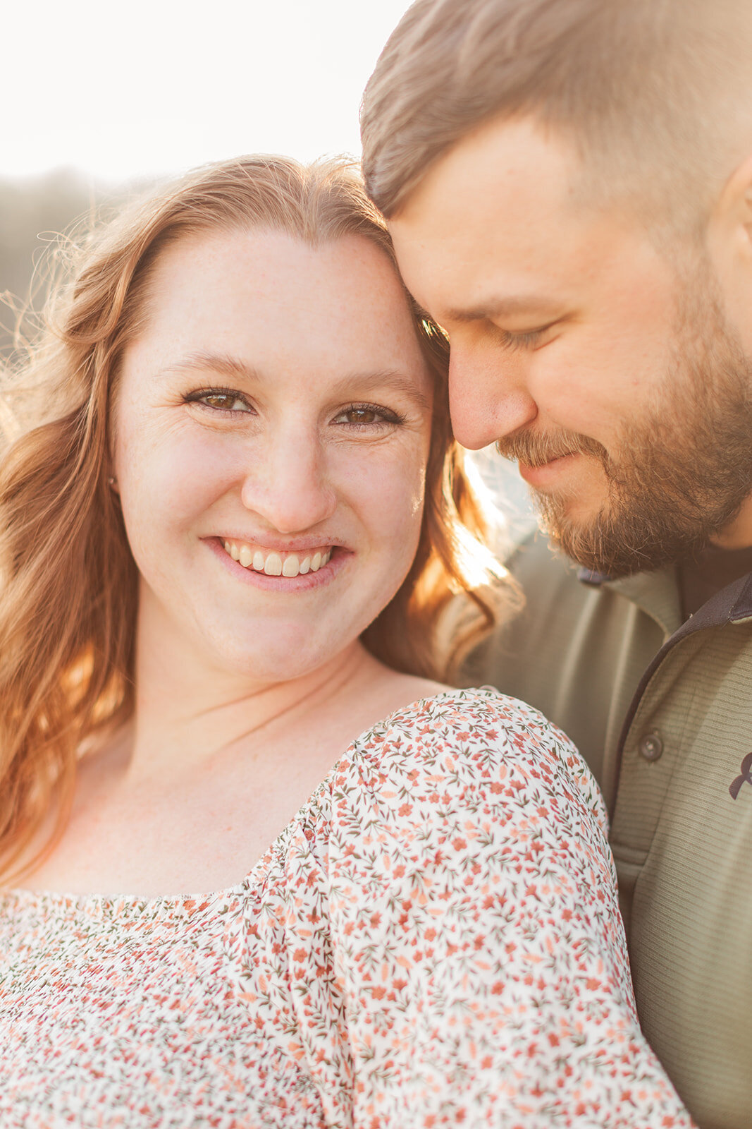 Pregnant couple smiling during spring maternity session