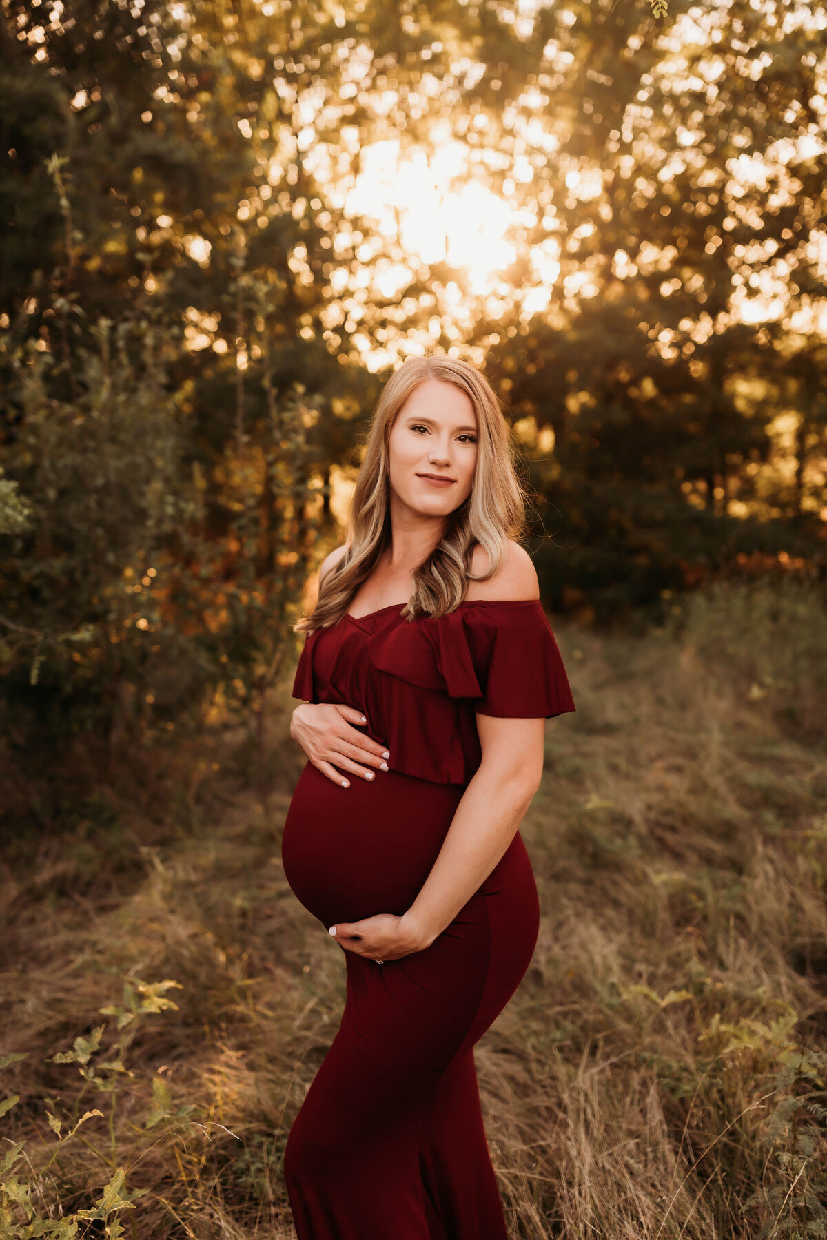 Pregnant mom in a maroon bodycon dress at golden hour