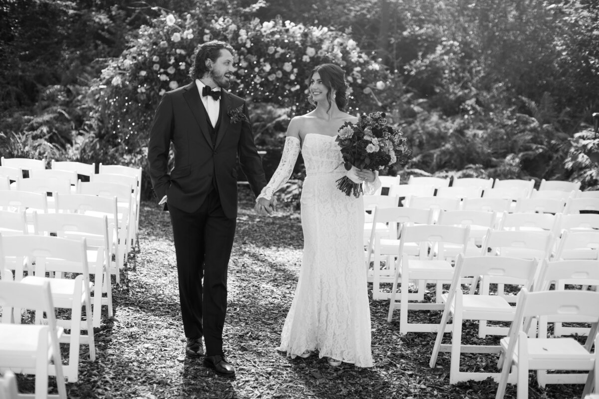 bride and groom photo walking down the isle in black and white