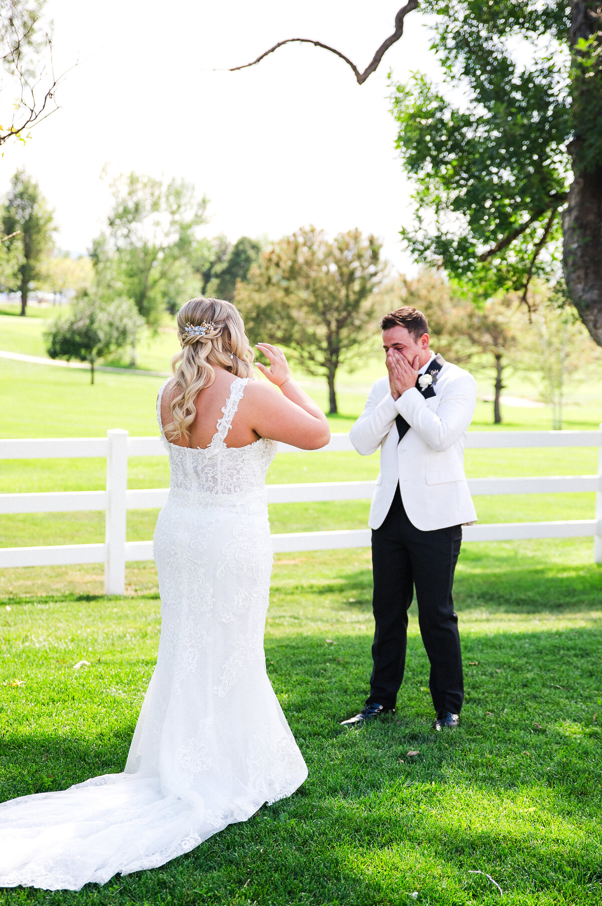A groom covers his mouth in amazement as he sees his bride for the first time at The Barn at Raccoon Creek in Denver, Colorado.