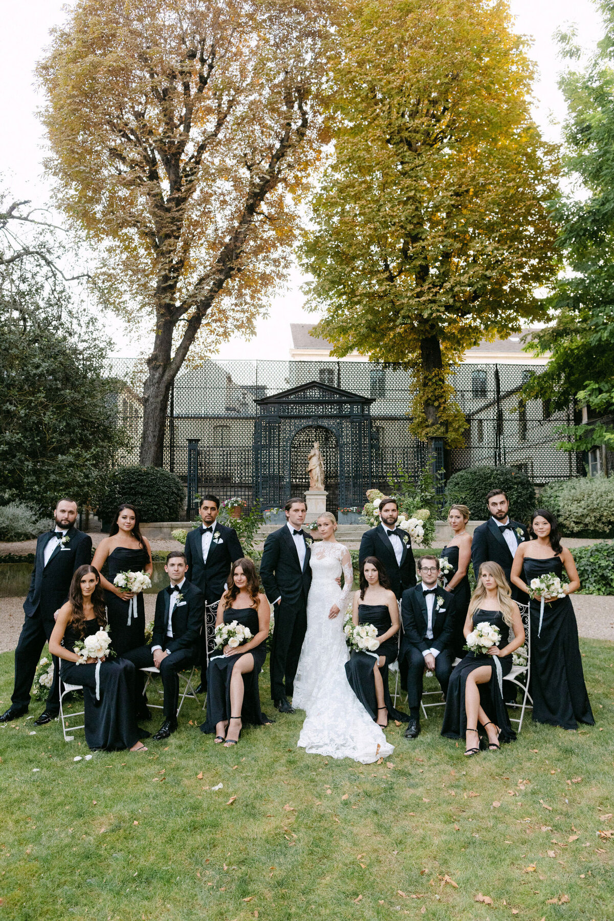 Bridal party and couple stylish group shot in the gardens.