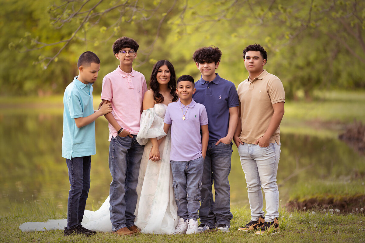 A beautiful family portrait in Dallas featuring a family of eight, captured by a Dallas family photographer by the water.