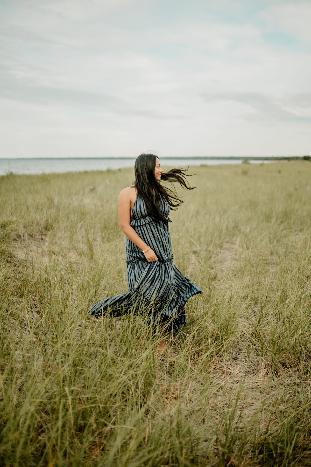 Graduating senior frolics along Minnesota Point beach in Duluth, Minnesota.