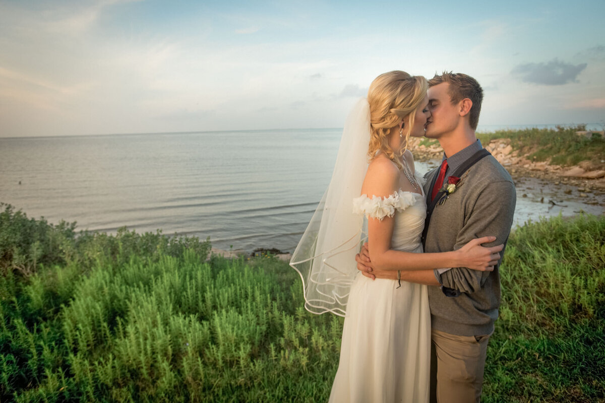 A husband and wife embrace and kiss each other after their Colorado wedding ceremony