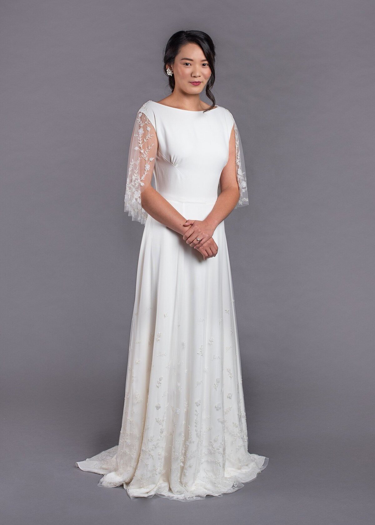The Dolores style is a slim a-line wedding dress with a beaded bridal capelet by indie bridal designer Edith Elan.